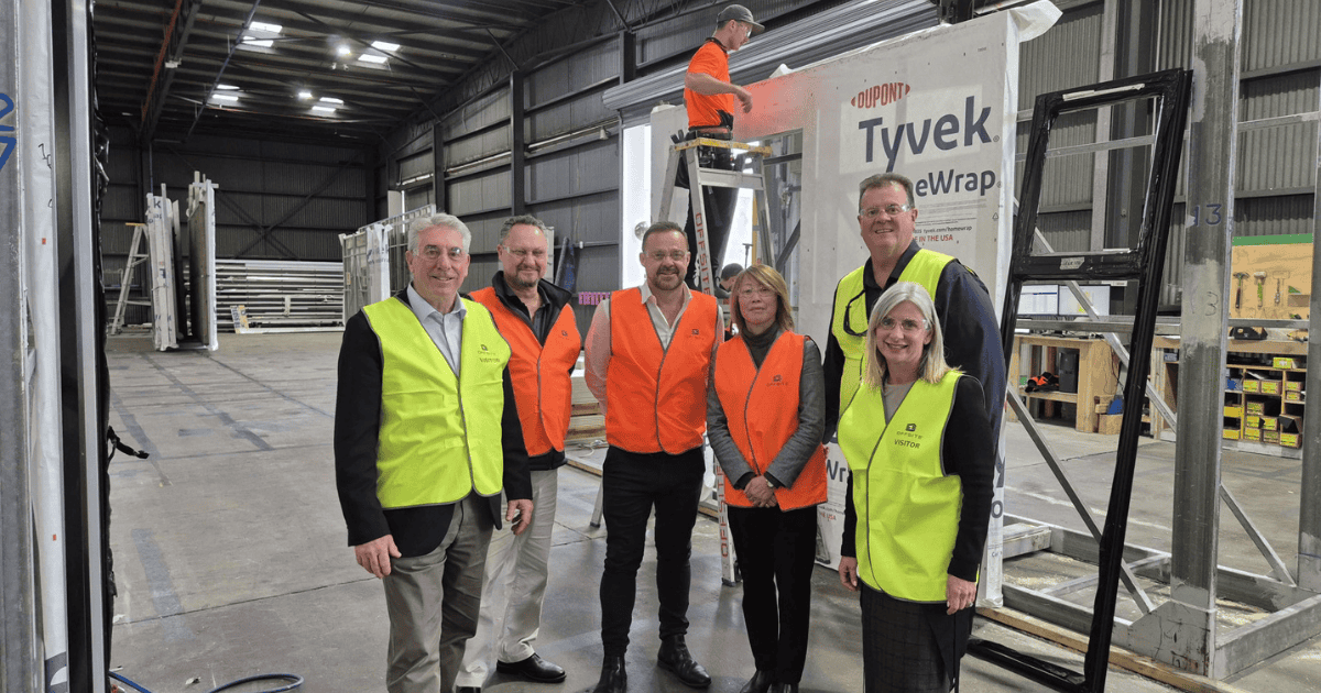 Sandra Brewer, David Bolt and the Offsite Team in orange vests standing in a warehouse.